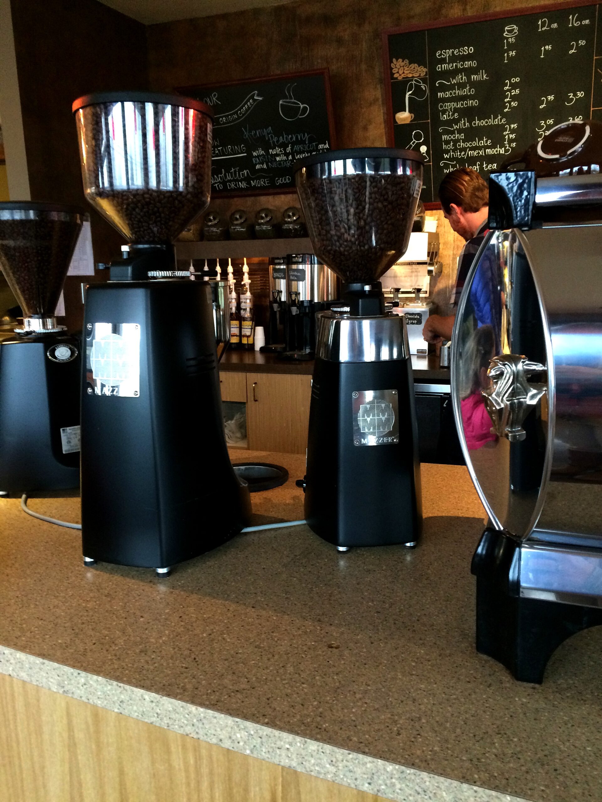 Containers filled with coffee beans stand on the front counter.